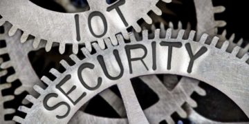 Macro photo of tooth wheel mechanism with IOT SECURITY letters imprinted on metal surface