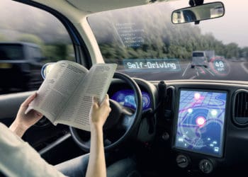 cockpit of autonomous car. a vehicle running self driving mode and a woman driver reading book.