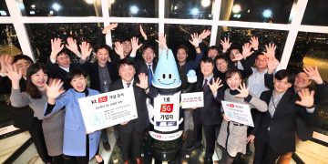 Lota, an AI robot and the first subscriber to KT’s 5G network commercial service, cheers with KT officials at the Lotte World Tower on December 1. PHOTO from KT Corp.