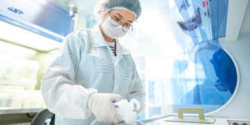 LEES researcher reviewing a 200 mm Silicon III-V wafer.